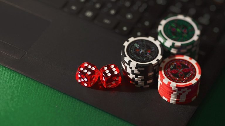 Casino chips stacked on a laptop keyboard, symbolizing online blackjack and digital gambling.