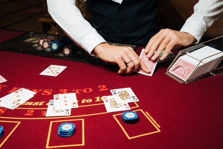 Casino dealer dealing blackjack cards on a red felt table during a training session with Card Counting Canada.