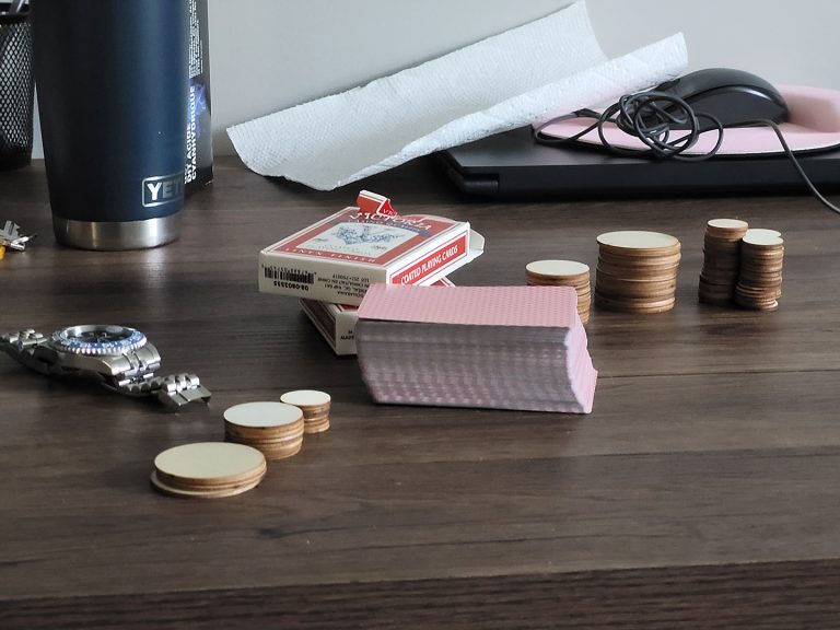 Two decks of cards and wooden chips on a table used for practicing card counting.